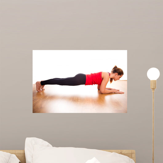 Young woman exercising - doing a plank in a studio
