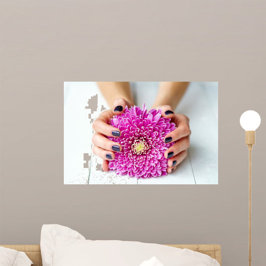 Hands with stylish dark manicure and pink flower