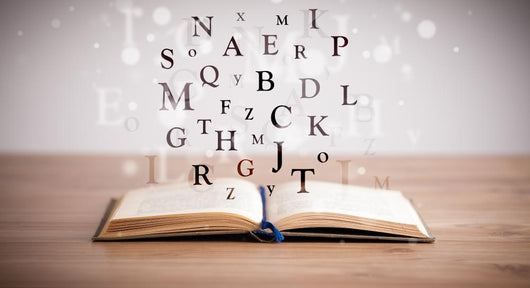 Opened book with flying letters