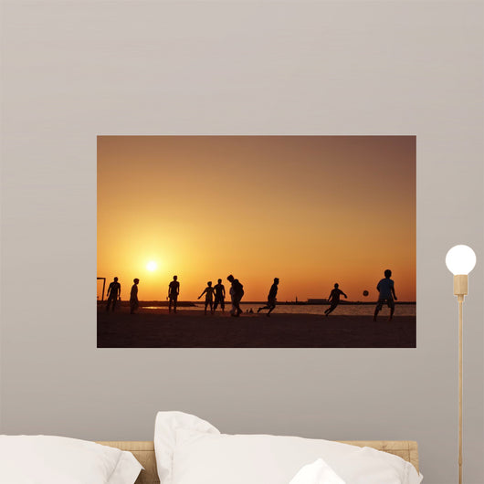Football at beach in Dubai during sunset. Wall Mural