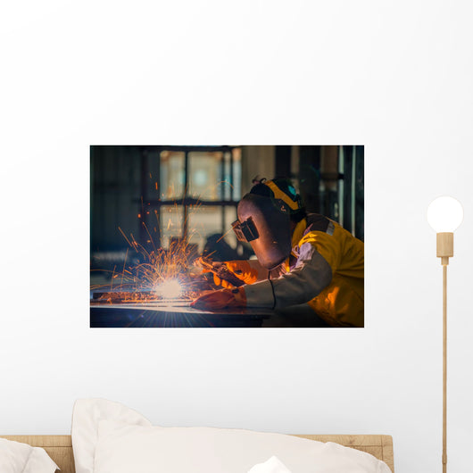 Worker welding the steel part by manual Wall Mural