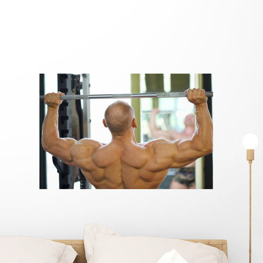 Back of Bodybuilder Raising Barbell in Gym Hall before Mirror Wall Mural