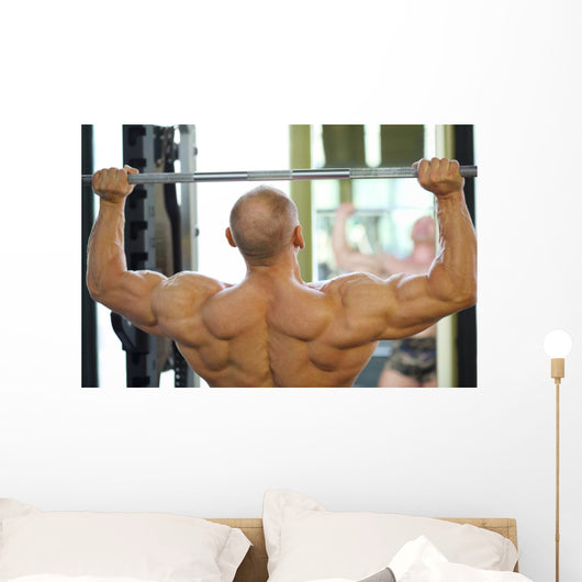 Back of Bodybuilder Raising Barbell in Gym Hall before Mirror Wall Mural
