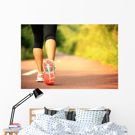 young fitness woman legs walking on forest trail  Wall Mural