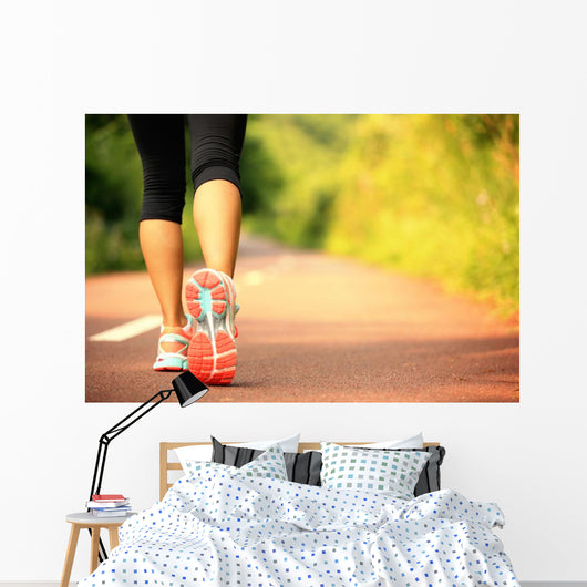 young fitness woman legs walking on forest trail  Wall Mural