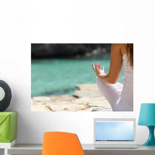 Detail of a woman hand doing yoga exercises on the beach Wall Mural