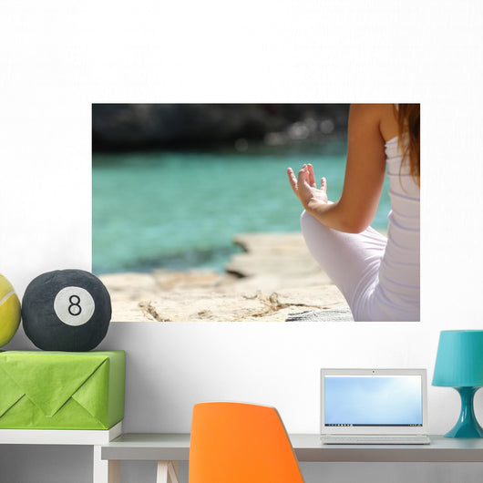 Detail of a woman hand doing yoga exercises on the beach Wall Mural