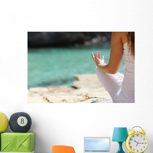 Detail of a woman hand doing yoga exercises on the beach Wall Mural