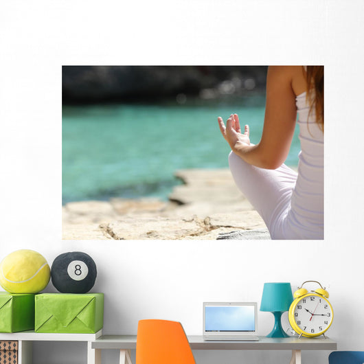 Detail of a woman hand doing yoga exercises on the beach Wall Mural