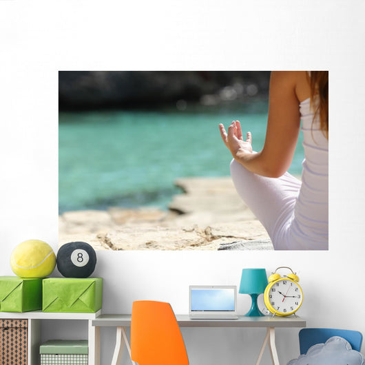 Detail of a woman hand doing yoga exercises on the beach Wall Mural