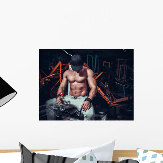 muscle shaped man tired sitting relaxed with weights and energy Wall Mural