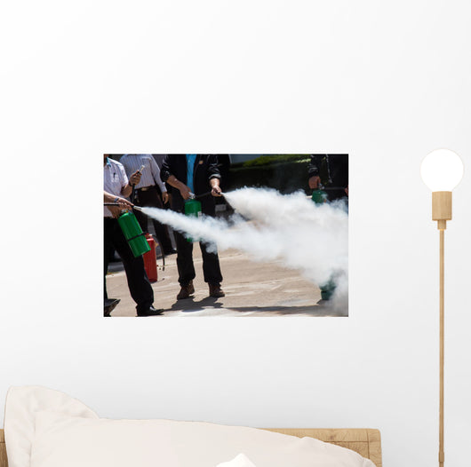 Instructor showing how to use a fire extinguisher on a training Wall Mural