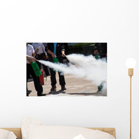 Instructor showing how to use a fire extinguisher on a training Wall Mural