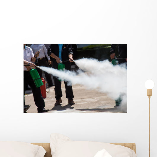 Instructor showing how to use a fire extinguisher on a training Wall Mural