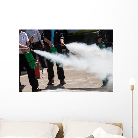 Instructor showing how to use a fire extinguisher on a training Wall Mural