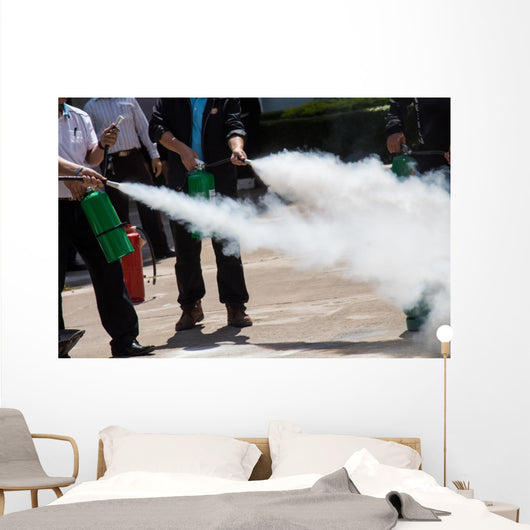 Instructor showing how to use a fire extinguisher on a training Wall Mural