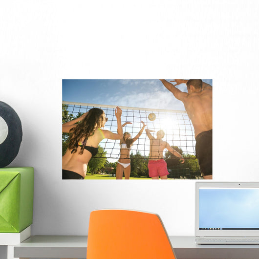 Friends play volleyball on the beach Wall Mural