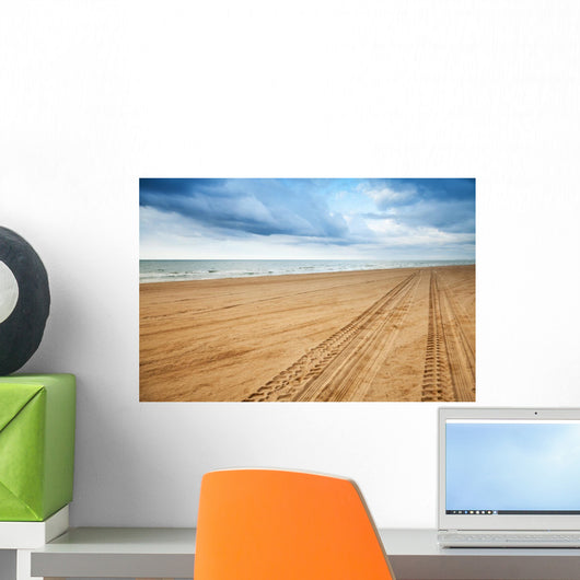 Perspective of tyre tracks on sandy beach Wall Mural