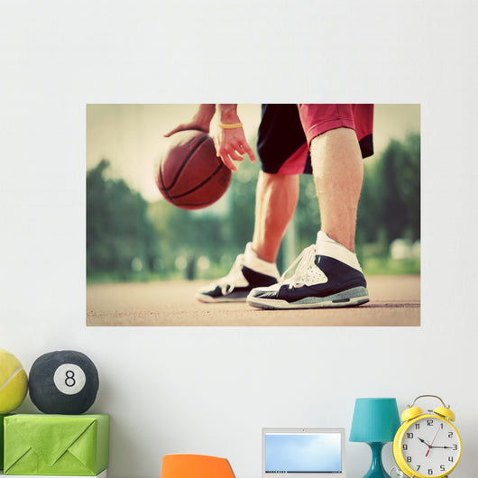 Young man on basketball court dribbling with bal Wall Mural