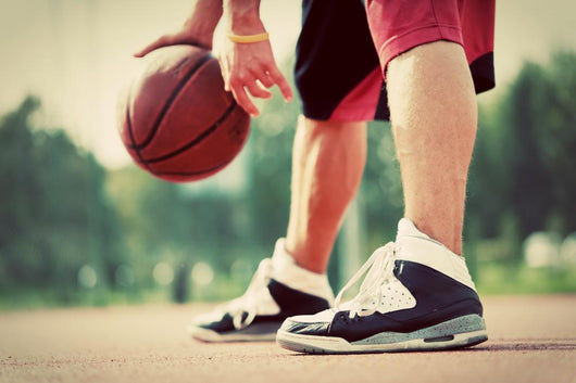 Young man on basketball court dribbling with bal Wall Mural