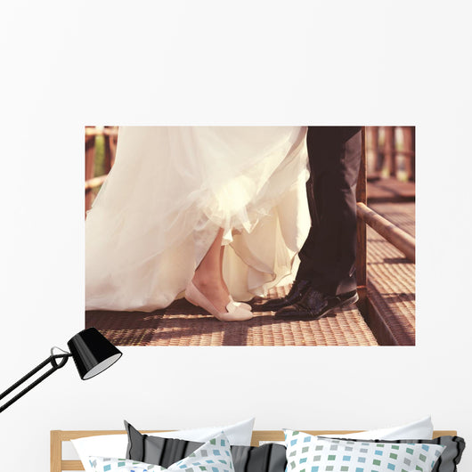 Bride and groom legs on a bridge Wall Mural