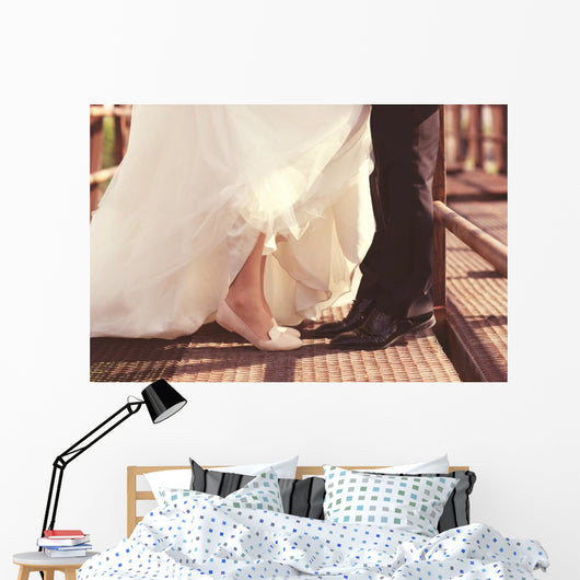 Bride and groom legs on a bridge Wall Mural
