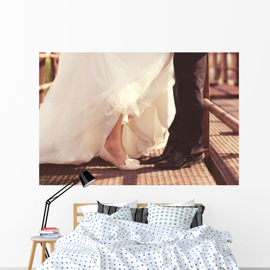 Bride and groom legs on a bridge Wall Mural