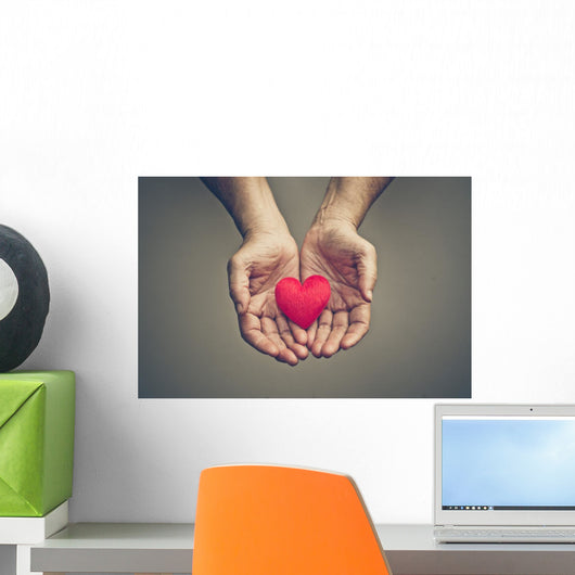 old hands of the elderly giving a red heart Wall Mural