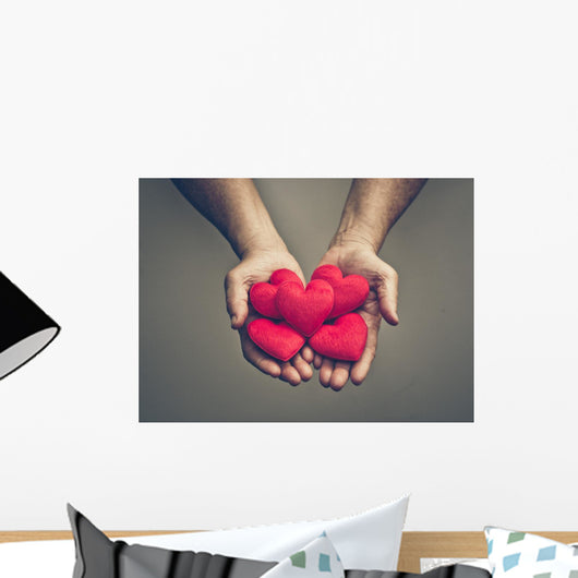 old hands of the elderly giving a red heart Wall Mural