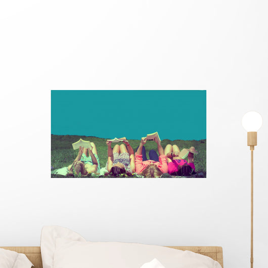 friends reading under sunshine lying on the meadow Wall Mural
