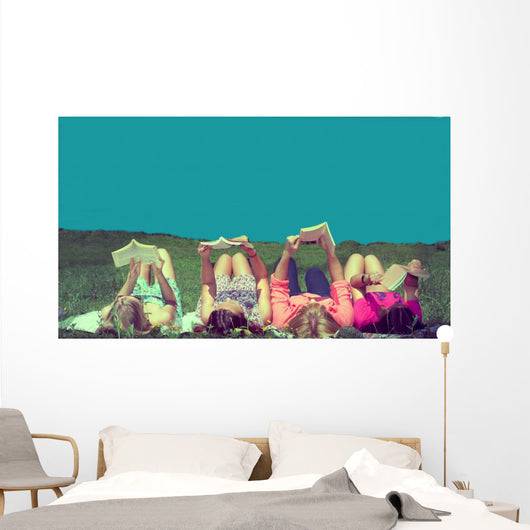 friends reading under sunshine lying on the meadow Wall Mural