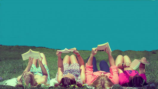 friends reading under sunshine lying on the meadow Wall Mural