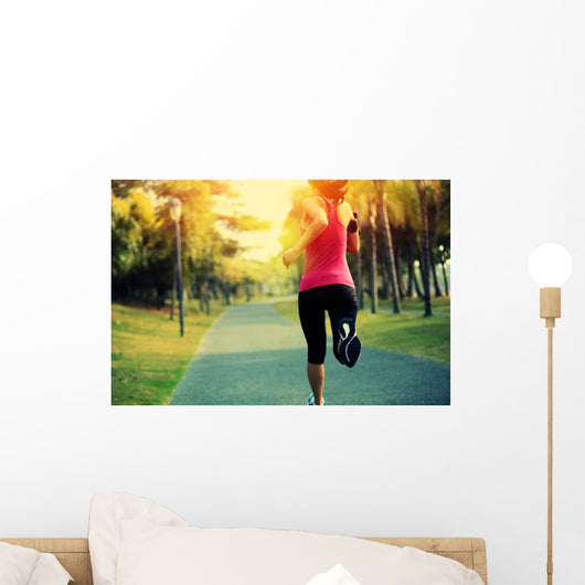 woman runner running at tropical park Wall Mural