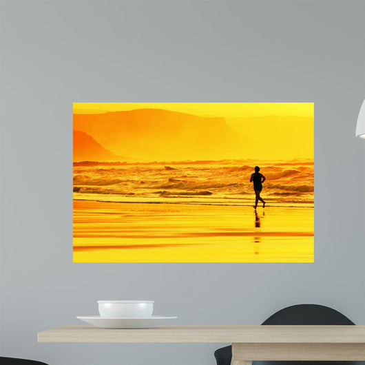 person running on beach at sunset Wall Mural