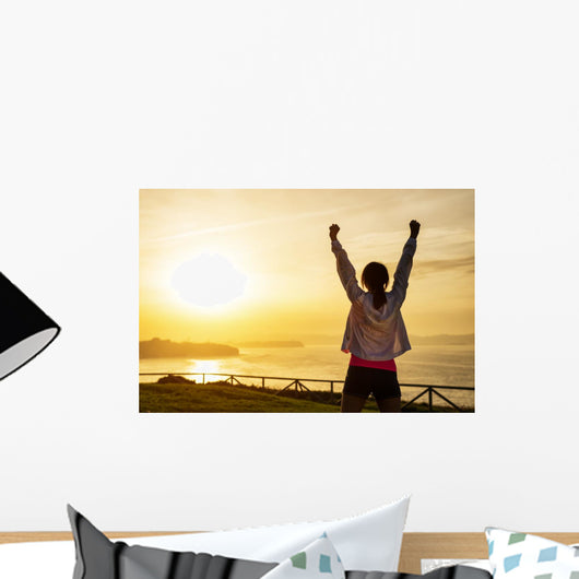 Successful sporty woman with arms up Wall Mural