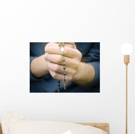 man prays with a rosary in hands Wall Decal
