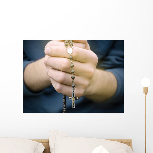 man prays with a rosary in hands Wall Decal