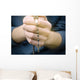 man prays with a rosary in hands Wall Decal