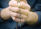 man prays with a rosary in hands Wall Decal