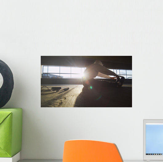Hooded athlete stretching before or after a workout Wall Decal