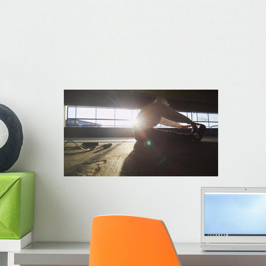 Hooded athlete stretching before or after a workout Wall Decal