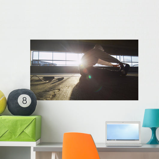 Hooded athlete stretching before or after a workout Wall Decal
