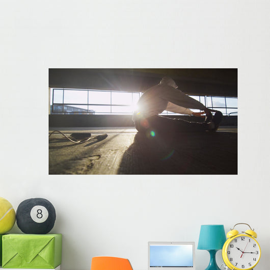Hooded athlete stretching before or after a workout Wall Decal