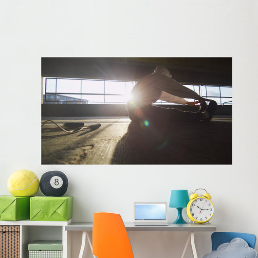 Hooded athlete stretching before or after a workout Wall Decal