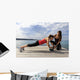 Young woman doing push-ups on a medicine ball with a coach Wall Decal