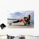 Young woman doing push-ups on a medicine ball with a coach Wall Decal