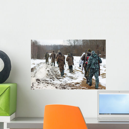 Group of hunters walking on the field in winter Wall Decal