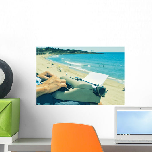 young man typewriting on the beach Wall Decal