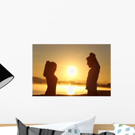 Silhouette of a fitness couple stretching at sunrise Wall Decal