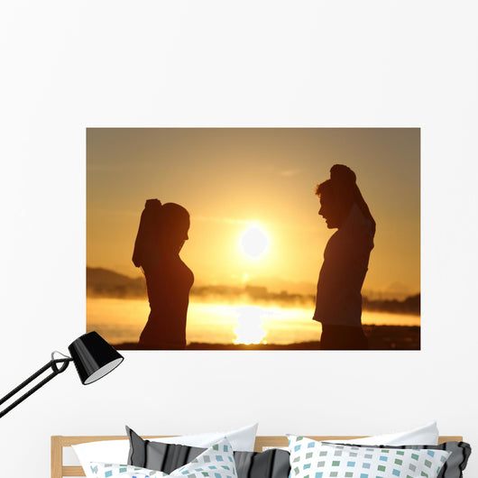 Silhouette of a fitness couple stretching at sunrise Wall Decal